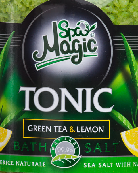 Close-up of the Tonic label: green tea leaves and lemon wedges either side of the name