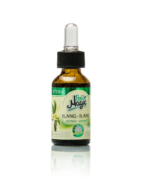 Flacon de ulei de ylang-ylang pe o suprafață albă reflectantă